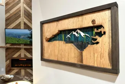 State pride meets artistry — this unique wall art combines the outline of North Carolina with a detailed nighttime mountain landscape, perfect for adding character to the family room. ️✨