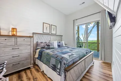 Basement king bedroom.  This quiet, cozy space features a king bed with luxury bedding and a dresser chest for clothes storage, plus easy deck access for fresh air.