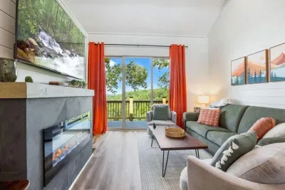 Settle into a thoughtfully styled family room featuring cozy seating, a contemporary electric fireplace, and expansive views that make every moment feel calm and elevated.