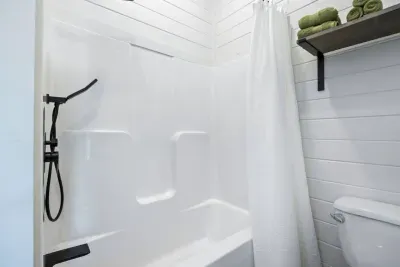 Connected to the second king bedroom, this ensuite bathroom includes rich bronze fixtures and a handheld shower wand, blending function with a touch of sophistication.