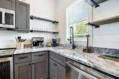 This well-crafted kitchen corner offers single-cup and full-pot coffee makers with complimentary K-cups, along with a modern dishwasher and expansive counters for a luxurious and convenient stay.