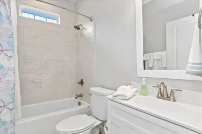 Bright & refreshing!  This hallway guest bathroom features a tiled shower/tub combo and a transom window for natural light.