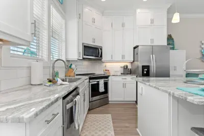 A kitchen made for coastal living!  Stainless steel appliances with an electric stovetop and plenty of space to gather make this the heart of your beach getaway.