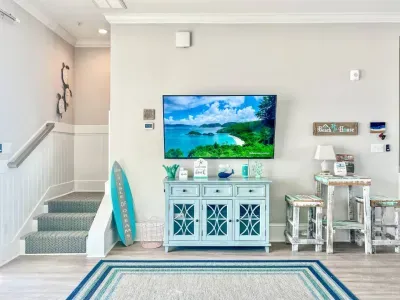 Featuring our recent upgrades — new stairwell rug and charming beadboard accents, as seen from the comfort of our cozy sectional sofa.