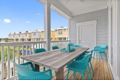 Enjoy a peaceful meal with beautiful poolside views!  This grey eucalyptus wood dining table with teal chairs seats six, making it the perfect spot for alfresco dining with family and friends.