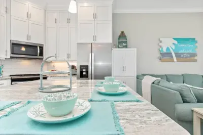 A home away from home!  Guests love our well-equipped kitchen, featuring ample pantry space to the right of the refrigerator and beautiful dishware, perfect for enjoying homemade meals after a day at the beach!