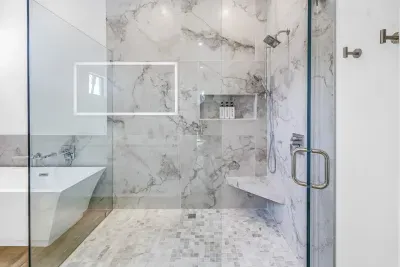 Spa-like bathroom with marble shower, soaking tub, and sleek modern finishes