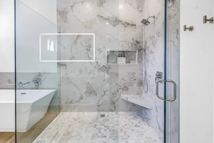 Spa-like bathroom with marble shower, soaking tub, and sleek modern finishes