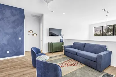 Bright modern lounge with blue accents, TV, and stylish seating