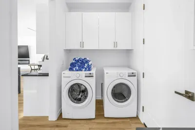 Bright in-unit laundry with full-size washer, dryer, and storage