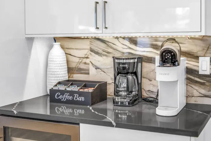 Modern coffee bar with Keurig, drip maker, and elegant marble backsplash