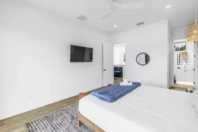 Bright modern bedroom with ensuite bath, TV, and serene minimalist style