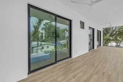 Spacious covered balcony with modern sliders and peaceful tree-lined views