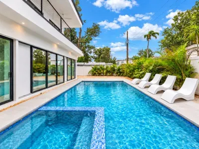 Resort-style private pool with tropical landscaping and sleek loungers