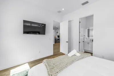 Bright modern bedroom with TV and private ensuite bath
