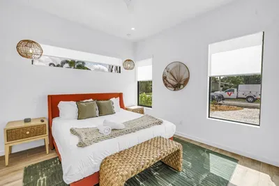 Bright coastal bedroom with king bed, natural light, and woven accents