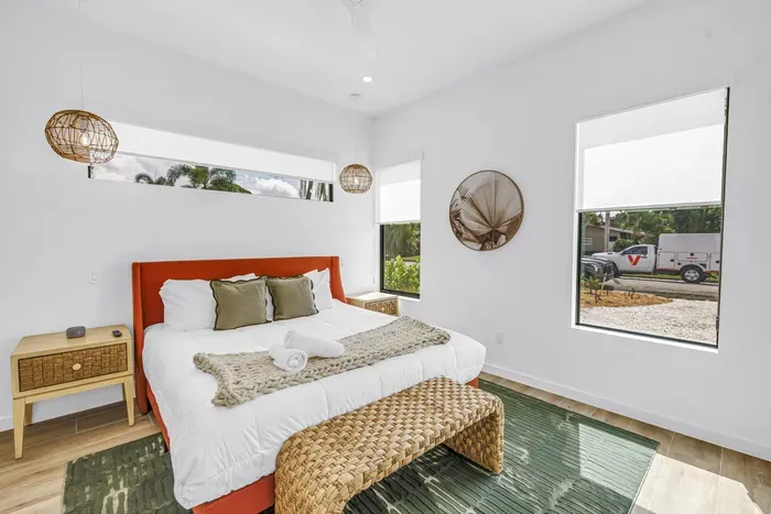 Bright coastal bedroom with king bed, natural light, and woven accents