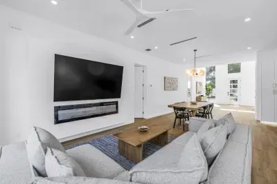Bright open-concept living area with plush seating, fireplace, and dining space