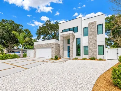 Striking modern exterior with stone accents, spacious drive, and upscale curb appeal