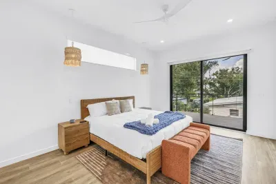 Bright modern bedroom with balcony views and warm natural finishes