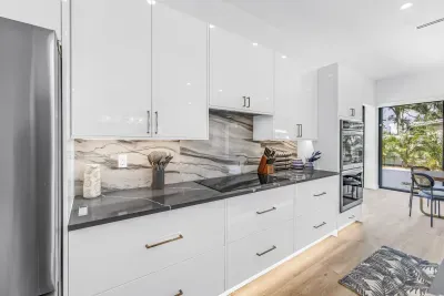 Bright designer kitchen with sleek finishes and sunny dining access