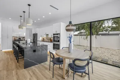 Bright designer kitchen with waterfall island and sunny dining area