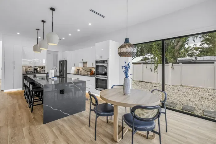 Bright designer kitchen with waterfall island and sunny dining area