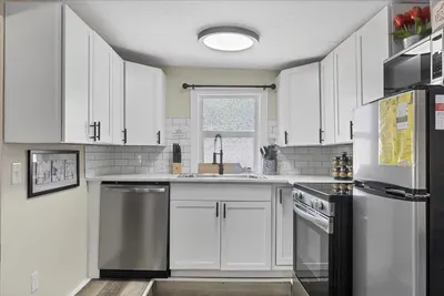 Bright U-shaped kitchen with stainless appliances and subway tile