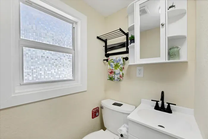 Bright bath with privacy glass, modern vanity, and smart storage.