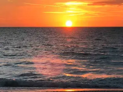 Stunning golden sunset over the waves—your serene beachfront escape