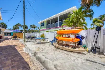 Tropical courtyard with kayaks, patio seating & screened balcony