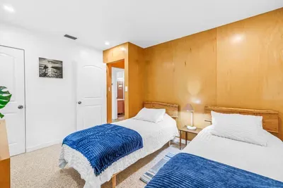 Bright twin bedroom with cozy wood accents and fresh modern styling