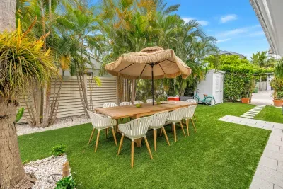 Tropical backyard dining oasis with lush palms and shaded seating