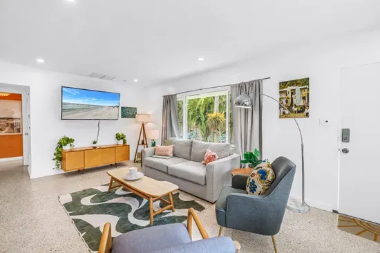 Bright tropical living room with cozy seating and garden-view patio doors