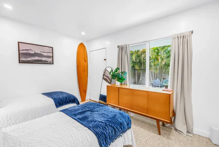 Bright twin bedroom with tropical views and relaxed coastal style
