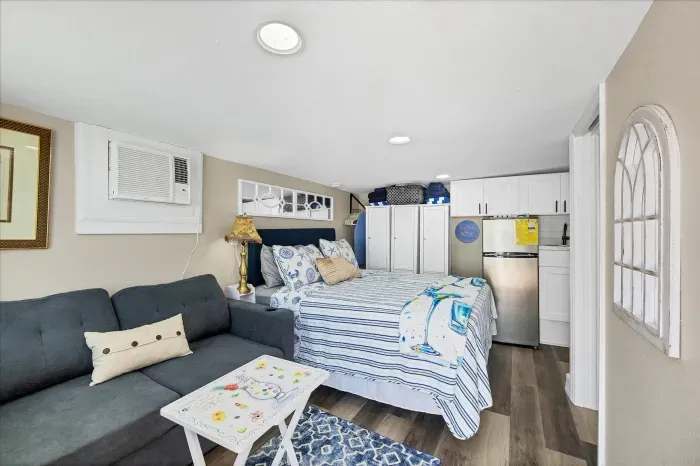 Bright coastal studio with sofa, kitchenette, and A/C comfort