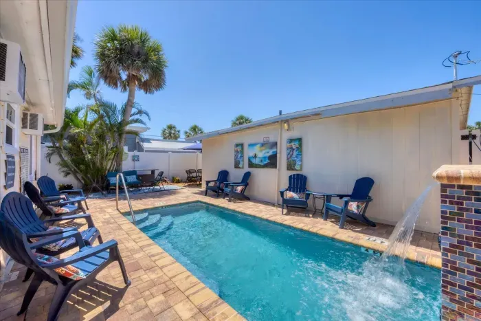 Private courtyard pool with waterfall, loungers & tropical vibe.