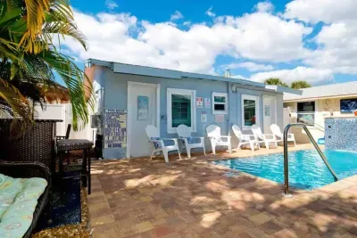 Sunny patio with sparkling pool, Adirondack chairs & coastal charm