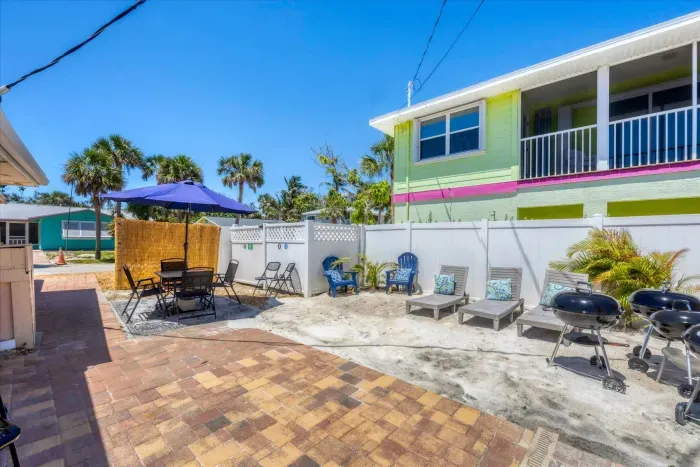 Beachy courtyard with loungers, grills & shaded dining near the sand