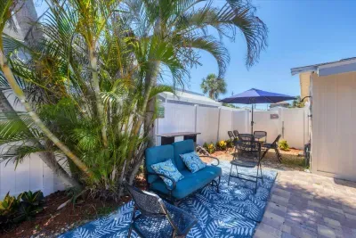 Private tropical patio with cushioned seating & umbrella dining
