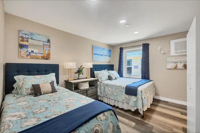 Bright coastal room with twin & full beds, AC, and chic decor