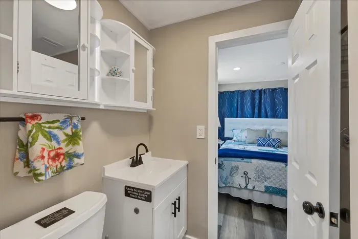 Bright bath with storage, steps from a cozy coastal bedroom