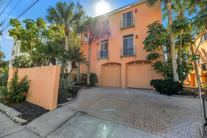 Exterior Entrance: Embrace tropical vibes in this charming retreat with vibrant landscaping!
