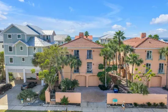 Charming Exterior: Discover vibrant coastal charm with lush palms and inviting Mediterranean style!