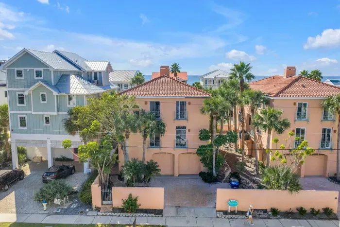 Charming Exterior: Discover vibrant coastal charm with lush palms and inviting Mediterranean style!