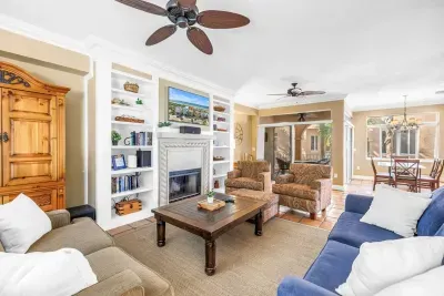 Living Room: Stylish space with vibrant seating, a cozy fire, and sunny views waiting for laughter!