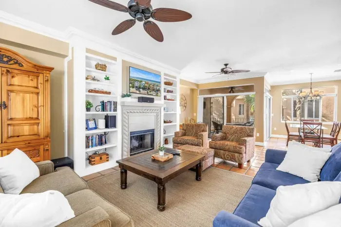 Living Room: Stylish space with vibrant seating, a cozy fire, and sunny views waiting for laughter!