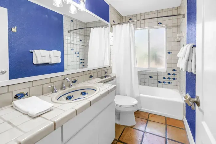 Bathroom Oasis: Vibrant tiles and bright lighting create a refreshing retreat after beach days.