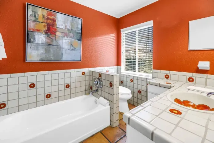 Charming Bathroom: Vibrant hues, vintage tile, and sunlight offer a refreshing retreat!