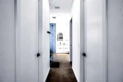 Bright modern hallway leading to a sleek spa-style bathroom